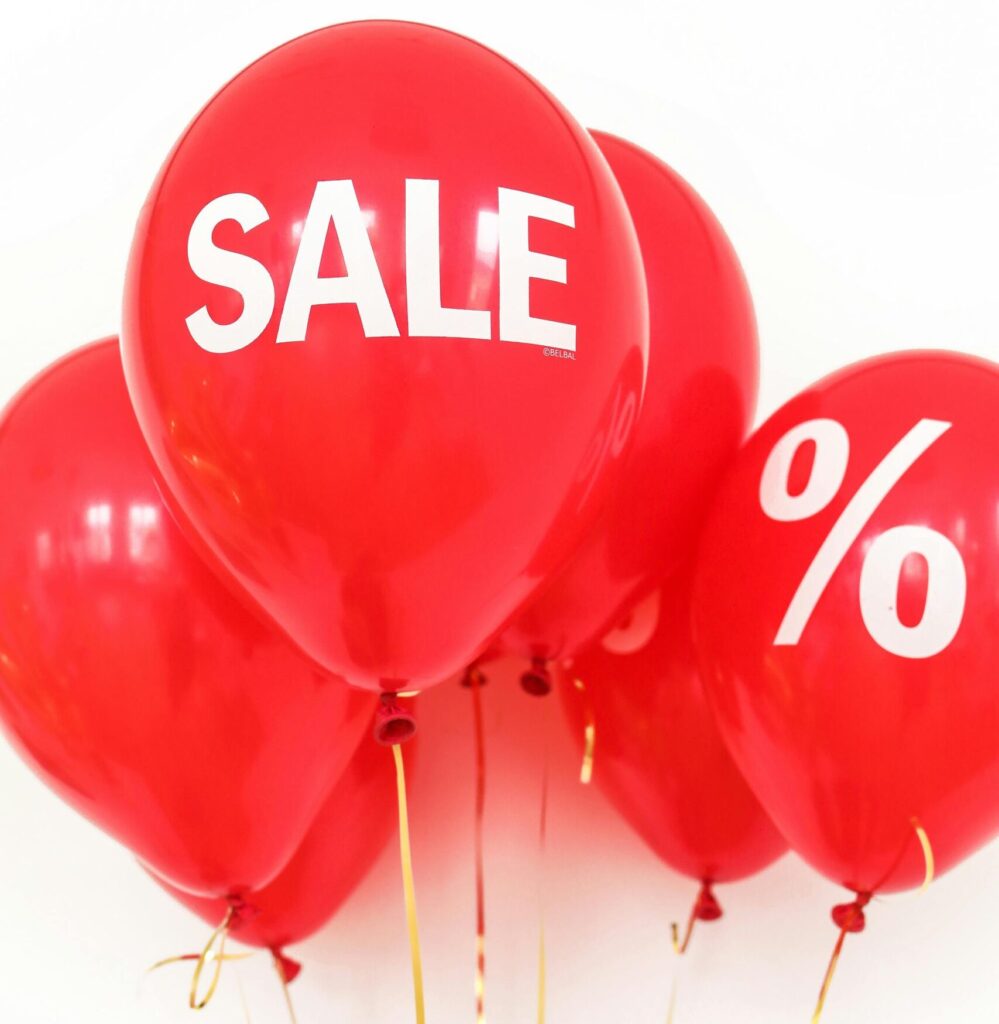 Bright red balloons with sale and percentage symbols for promotional advertising.