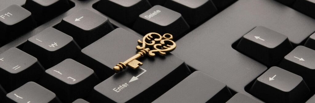 Close-up of an ornate vintage key placed on a modern computer keyboard.