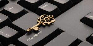 Close-up of an ornate vintage key placed on a modern computer keyboard.